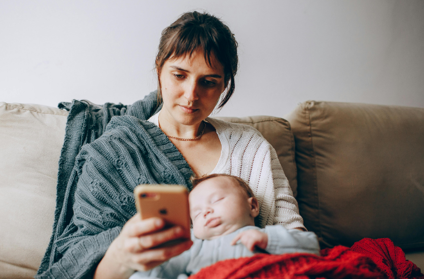 A mother alone on the couch with her baby