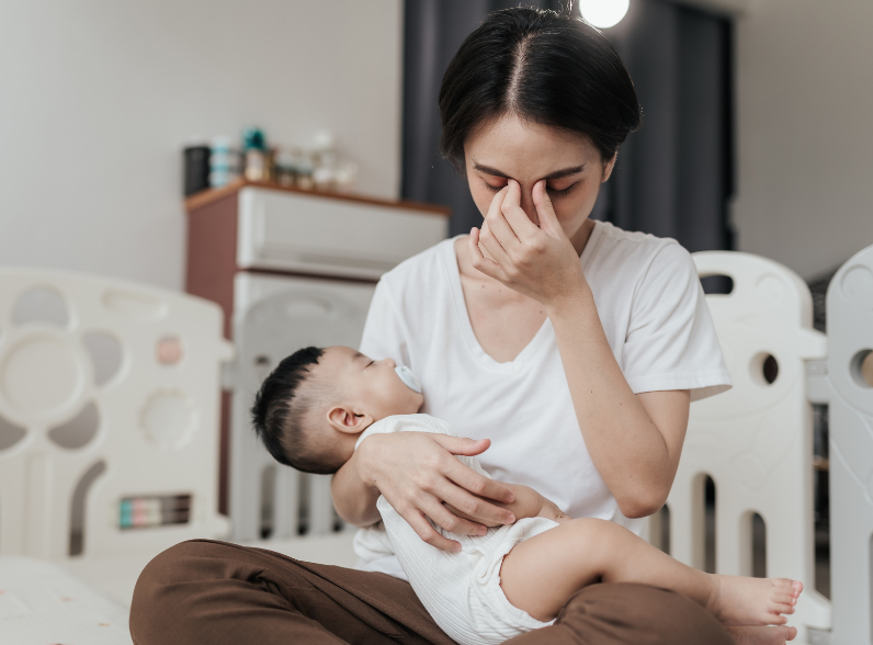 A tired mother holding her baby